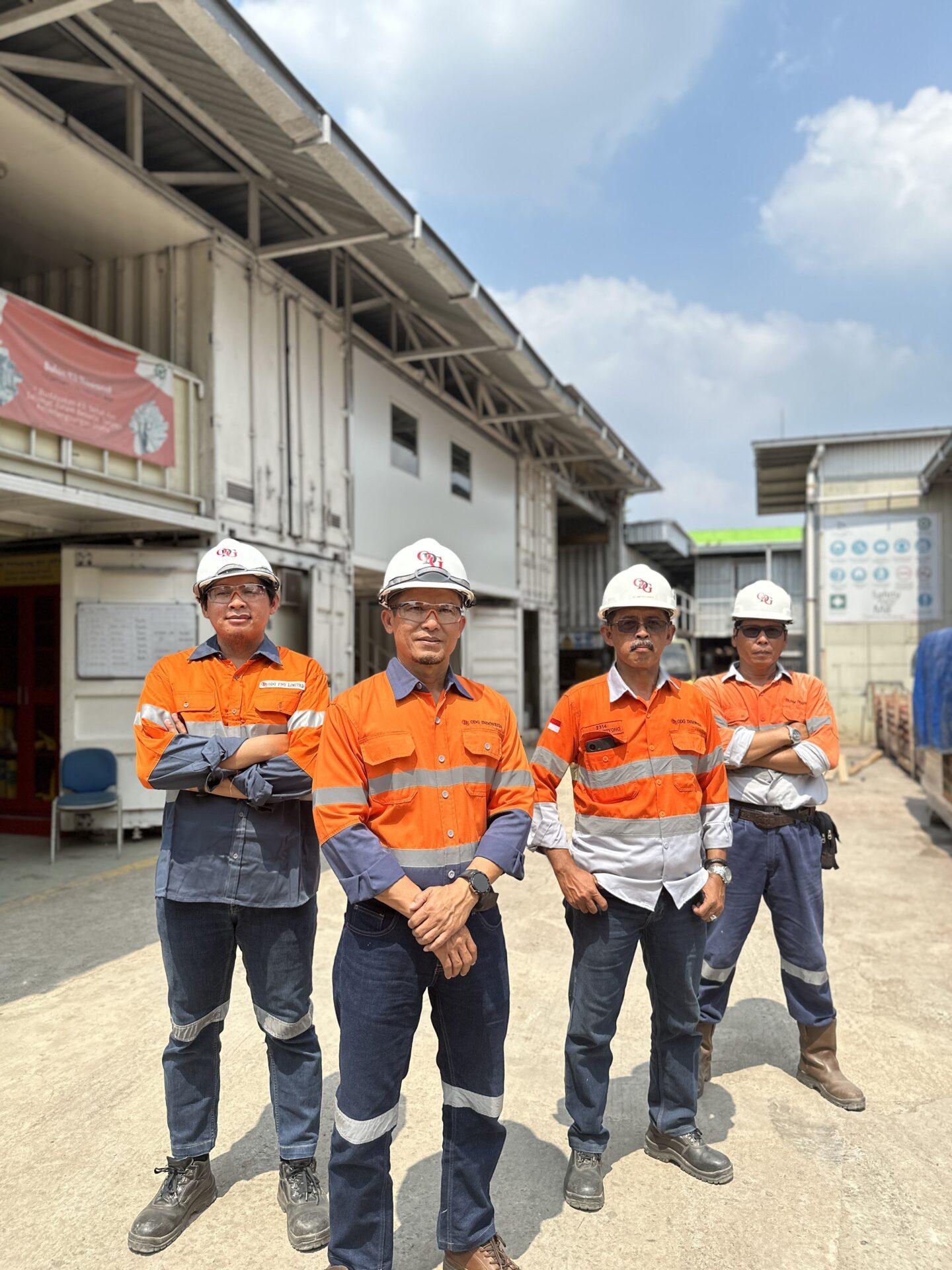 ODG Workshop Four men standing, wearing orange safety uniform and helmet with ODG logo